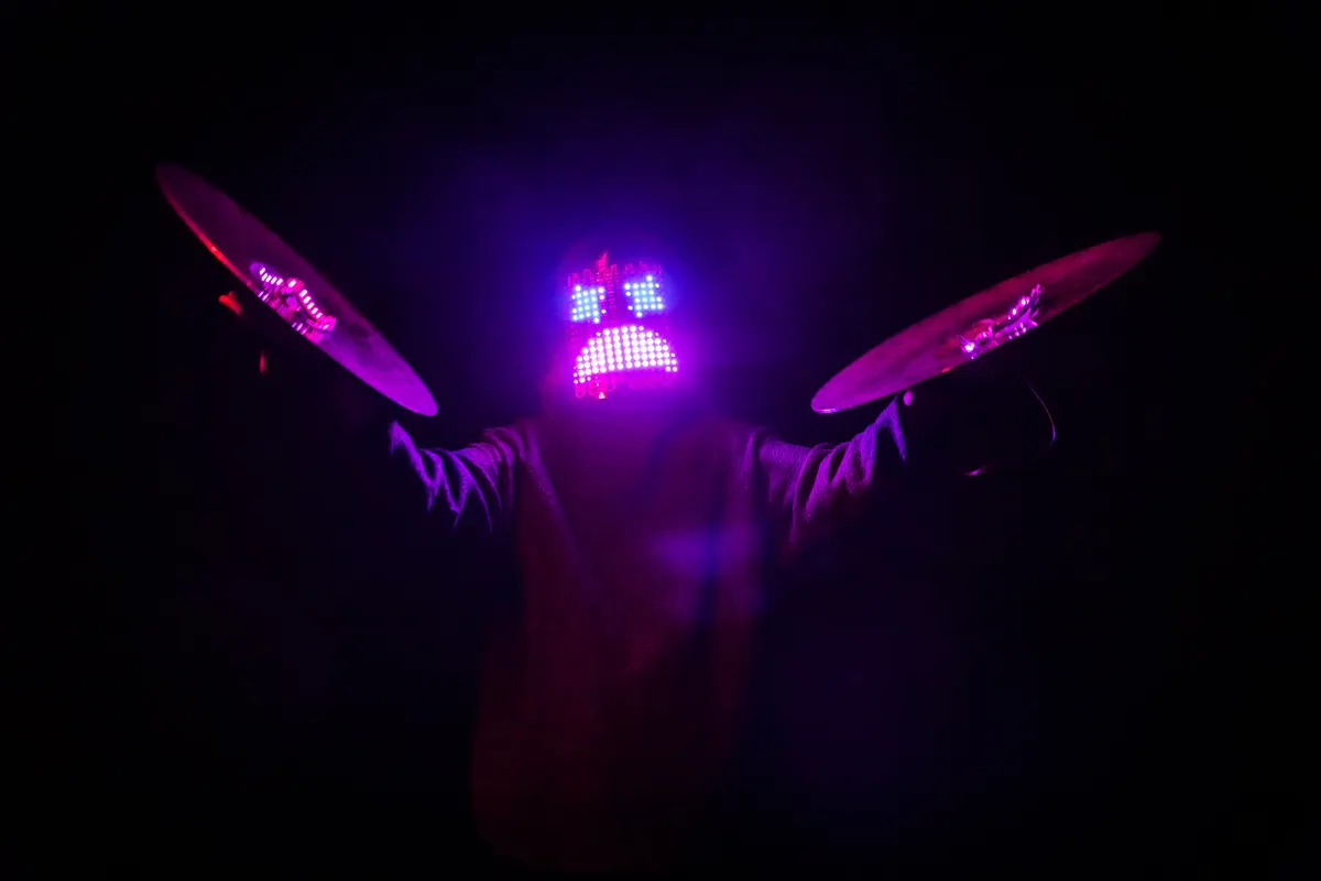 A LED drummer looking angry and playing with LED cymbals