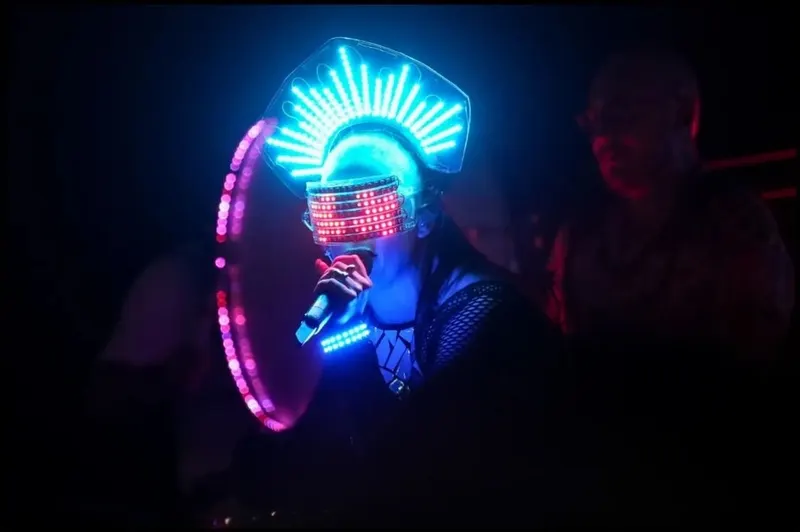 Instagram photo of an LED-masked performer playing an illuminated drum.